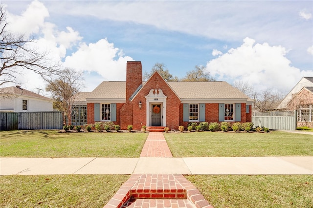 view of front of property featuring a front lawn, fence, brick siding, and a chimney