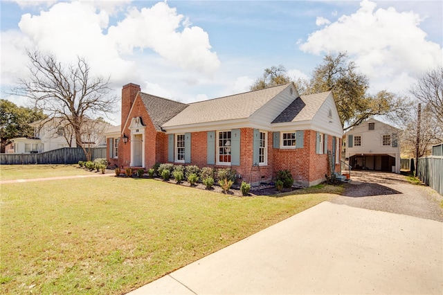 view of front of property featuring a front lawn, fence, concrete driveway, brick siding, and a chimney