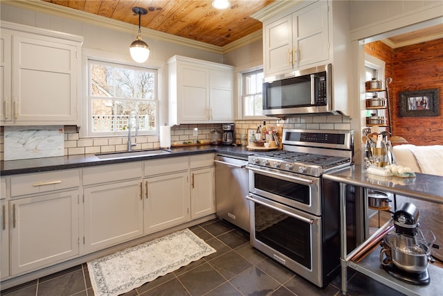 kitchen featuring a sink, dark countertops, appliances with stainless steel finishes, wooden ceiling, and crown molding