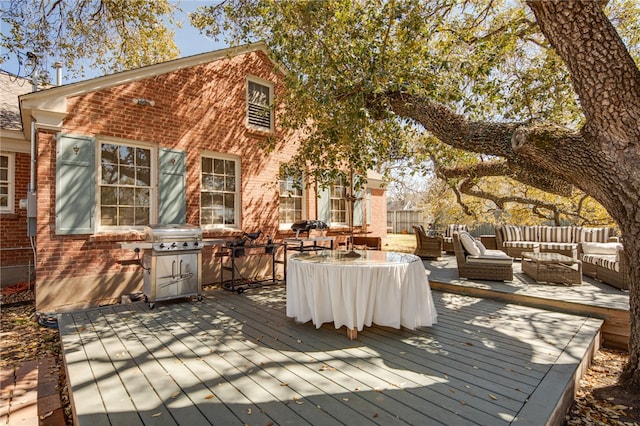 wooden deck with grilling area, fence, and an outdoor hangout area