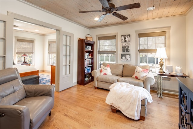 living room featuring light wood finished floors, wooden ceiling, ceiling fan, and ornamental molding