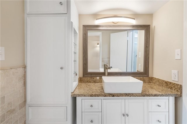 bathroom with vanity and tile walls