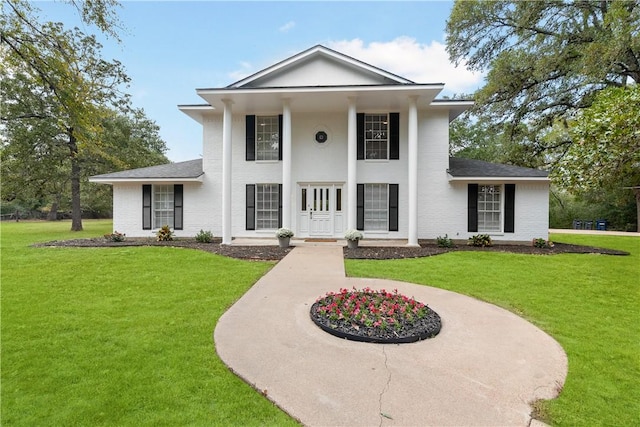 greek revival house featuring a front yard