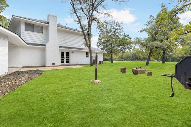 view of yard with french doors, an outdoor fire pit, and a patio area