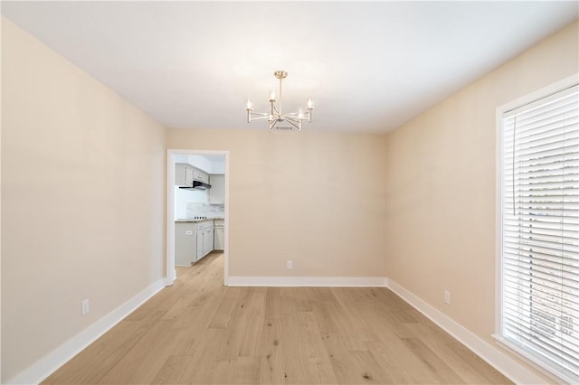 unfurnished dining area featuring light hardwood / wood-style floors and a notable chandelier