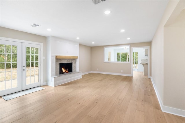 unfurnished living room featuring light hardwood / wood-style flooring and french doors