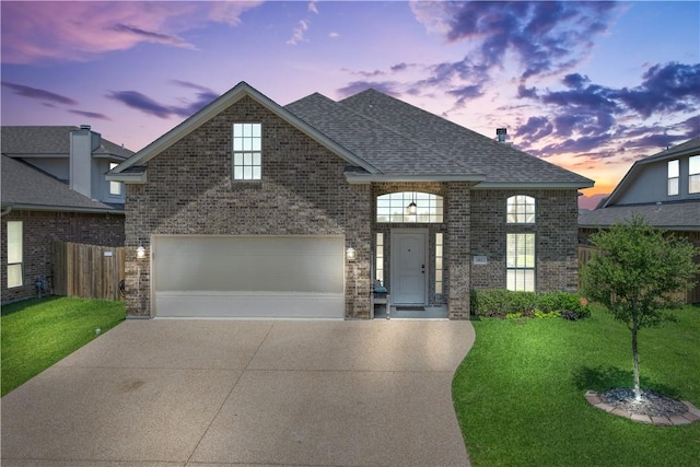 front facade featuring a lawn and a garage