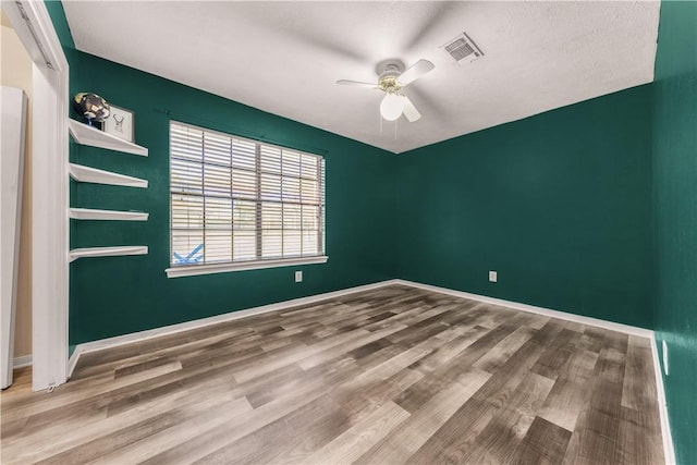 spare room featuring wood-type flooring and ceiling fan