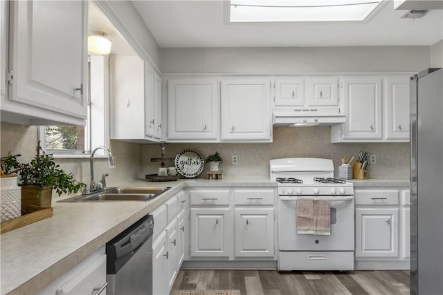 kitchen with decorative backsplash, stainless steel appliances, sink, wood-type flooring, and white cabinetry