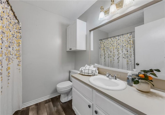 bathroom with toilet, vanity, and hardwood / wood-style flooring