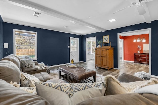 living room featuring ceiling fan with notable chandelier, beam ceiling, and light wood-type flooring