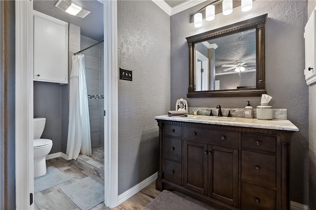 full bath featuring a shower with curtain, toilet, baseboards, a textured wall, and vanity