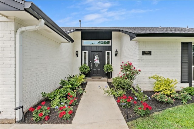 view of exterior entry featuring brick siding
