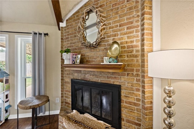 room details with baseboards, a fireplace, wood finished floors, and beam ceiling