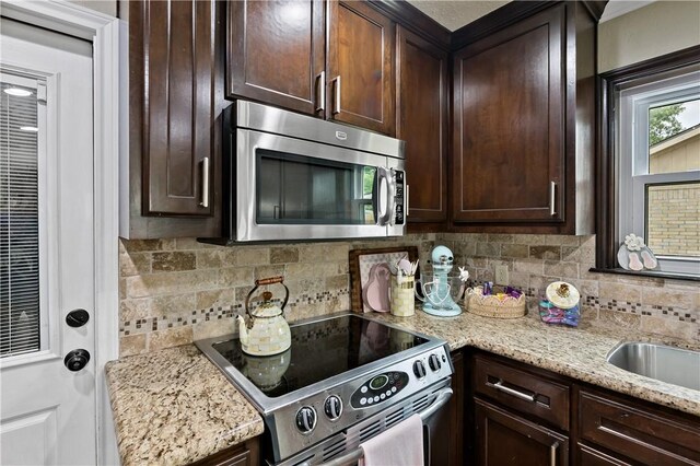 kitchen with tasteful backsplash, dark brown cabinets, and stainless steel appliances