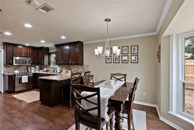 kitchen featuring dark brown cabinetry, stainless steel appliances, backsplash, a peninsula, and visible vents