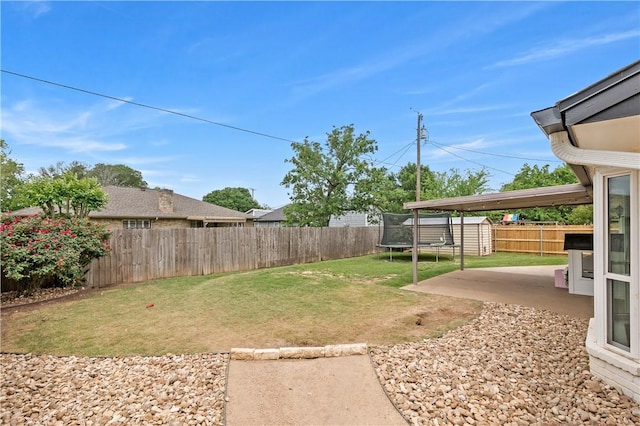 view of yard featuring a fenced backyard, a trampoline, an outdoor structure, a shed, and a patio