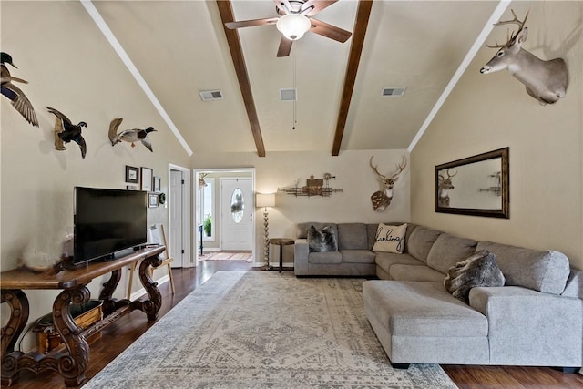 living area featuring wood finished floors, visible vents, and vaulted ceiling with beams