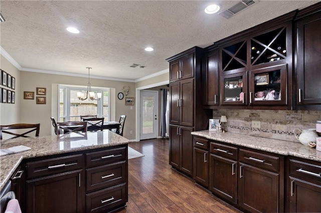 kitchen with dark wood-type flooring, backsplash, a chandelier, and crown molding