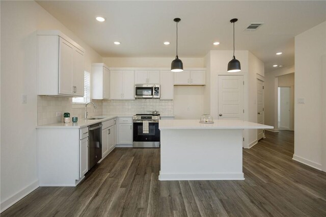 kitchen featuring stainless steel appliances, sink, a kitchen island, and white cabinets