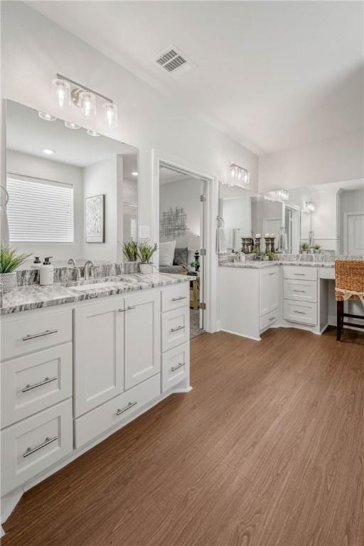 9868 Albert Dr, Iola, TX 77861 - full bath featuring wood finished floors and two vanities