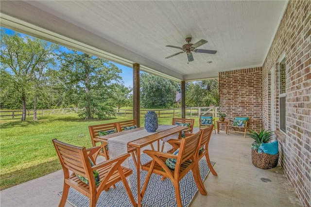 9868 Albert Dr, Iola, TX 77861 - fenced backyard featuring a patio, ceiling fan, outdoor dining area, and view of wooded area