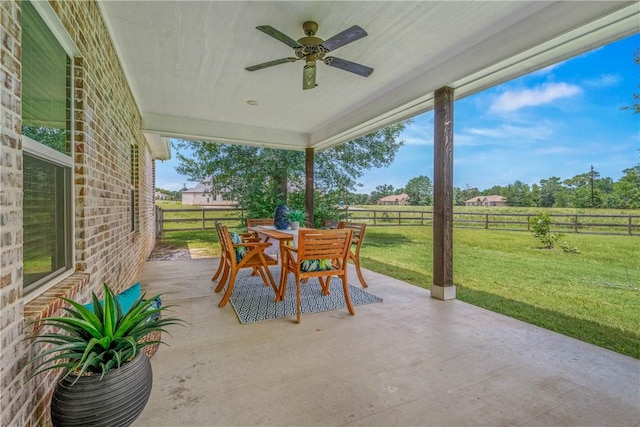 9868 Albert Dr, Iola, TX 77861 - fenced backyard featuring a patio, outdoor dining space, and a ceiling fan
