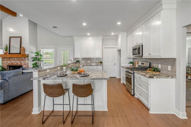 9868 Albert Dr, Iola, TX 77861 - kitchen with appliances with stainless steel finishes, open floor plan, light wood-type flooring, recessed lighting, and lofted ceiling