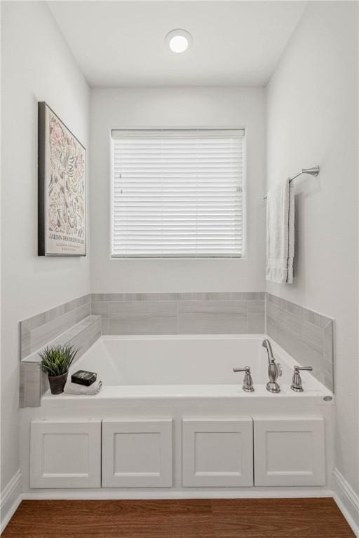 9868 Albert Dr, Iola, TX 77861 - bathroom featuring healthy amount of natural light, a garden tub, and wood finished floors