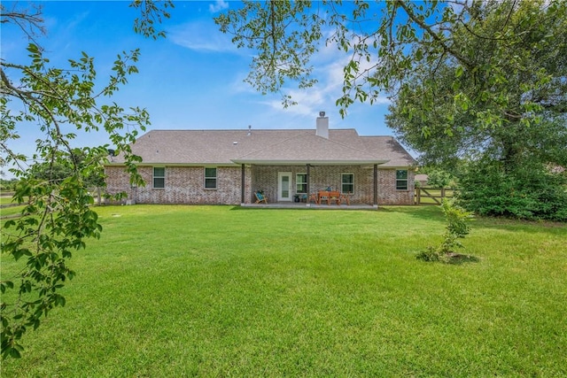 9868 Albert Dr, Iola, TX 77861 - rear view of house featuring a chimney, a patio area, and brick siding