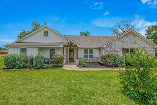 9868 Albert Dr, Iola, TX 77861 - view of front of property with a front lawn, roof with shingles, brick siding, and board and batten siding