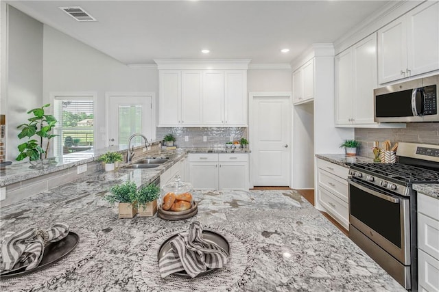 9868 Albert Dr, Iola, TX 77861 - kitchen featuring appliances with stainless steel finishes, tasteful backsplash, white cabinetry, and recessed lighting