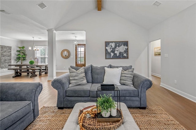 9868 Albert Dr, Iola, TX 77861 - living room with a chandelier, ornate columns, and wood finished floors