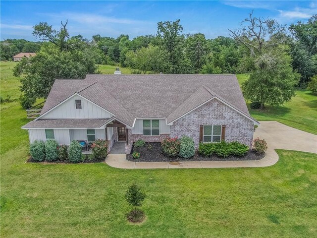 9868 Albert Dr, Iola, TX 77861 - view of front of property featuring a front yard, a chimney, board and batten siding, and brick siding