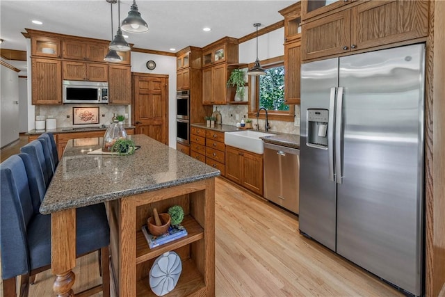 kitchen featuring hanging light fixtures, sink, a breakfast bar area, and appliances with stainless steel finishes