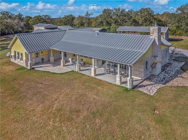 rear view of property with a lawn and a patio area