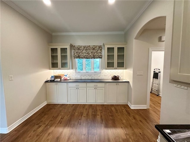 114 Hayes Church Rd, Franklin, TX 77856 - kitchen featuring arched walkways, backsplash, dark wood-type flooring, glass insert cabinets, and crown molding