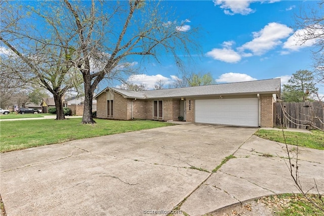 view of front facade with brick siding, concrete driveway, an attached garage, fence, and a front yard