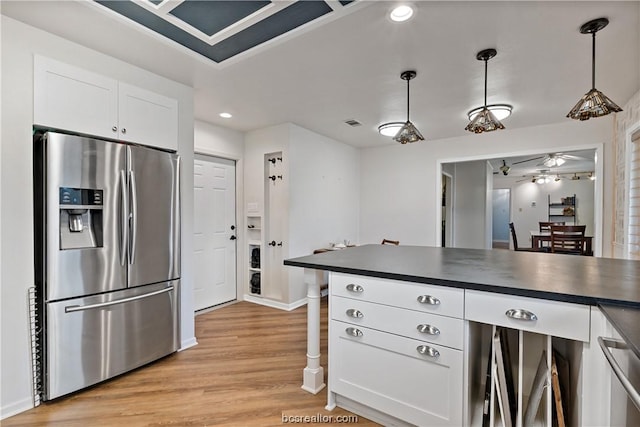 kitchen featuring white cabinetry, ceiling fan, light hardwood / wood-style flooring, stainless steel fridge, and pendant lighting