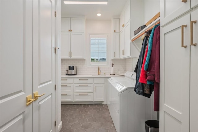 washroom with washing machine and clothes dryer, recessed lighting, cabinet space, a sink, and dark tile patterned flooring