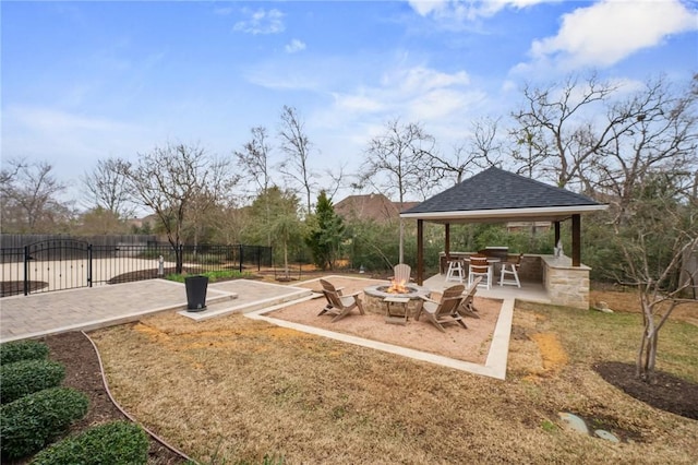 view of home's community with fence, a fire pit, and a gazebo