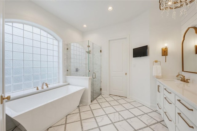 bathroom with recessed lighting, a freestanding bath, a stall shower, vanity, and baseboards