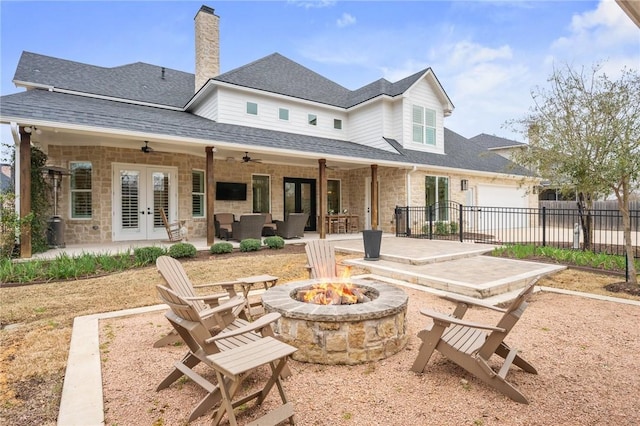 back of house with a patio, stone siding, ceiling fan, fence, and french doors