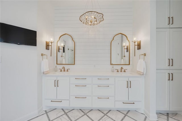 bathroom featuring double vanity, a sink, and baseboards