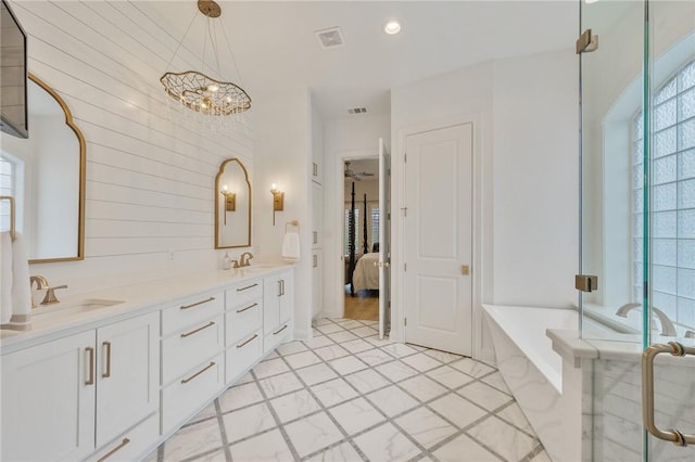 ensuite bathroom with a garden tub, a stall shower, a sink, and ensuite bath