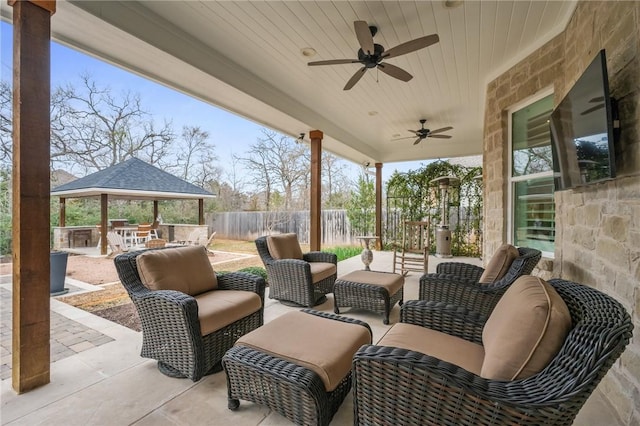 view of patio / terrace with a ceiling fan, fence, a gazebo, and an outdoor hangout area