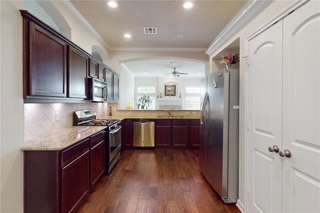 2515 Warkworth Ln, College Station, TX 77845 - kitchen featuring appliances with stainless steel finishes, a sink, a ceiling fan, dark wood-type flooring, and light stone countertops
