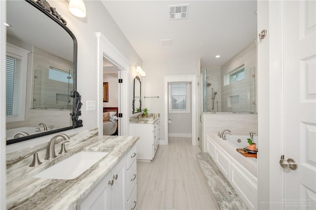 full bathroom with visible vents, a garden tub, two vanities, a sink, and a stall shower