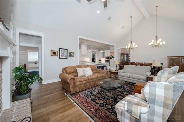 living room featuring high vaulted ceiling, baseboards, beamed ceiling, ceiling fan with notable chandelier, and light wood-style floors