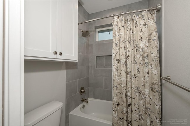 bathroom featuring toilet and shower / bath combination with curtain